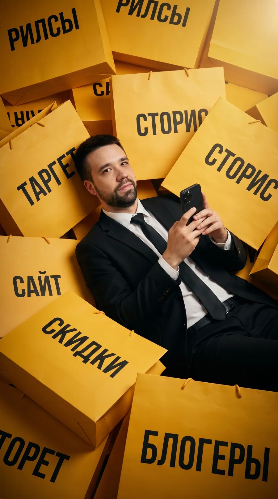 Юрий Раевский среди пакетов с надписями: рилсы, сторис, таргет, сайт, скидки, блогеры